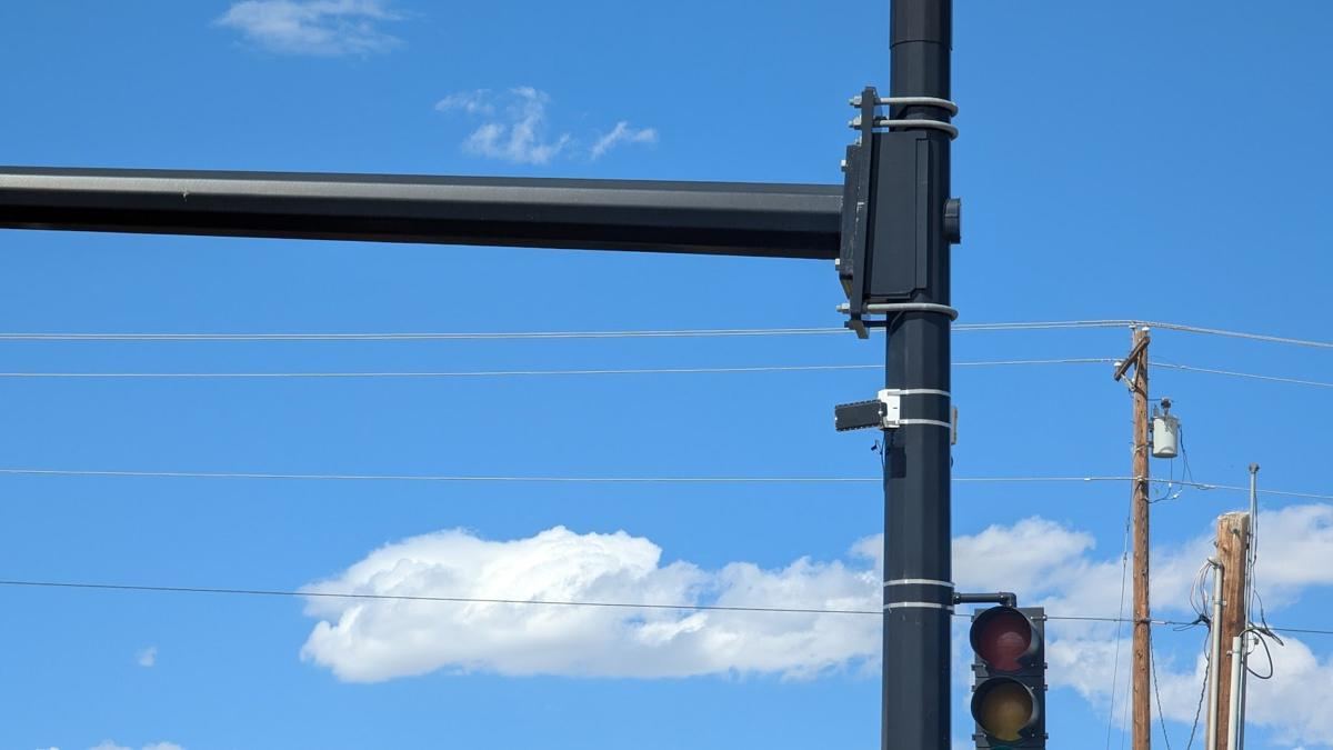 Sensor on a signal mast arm against blue sky