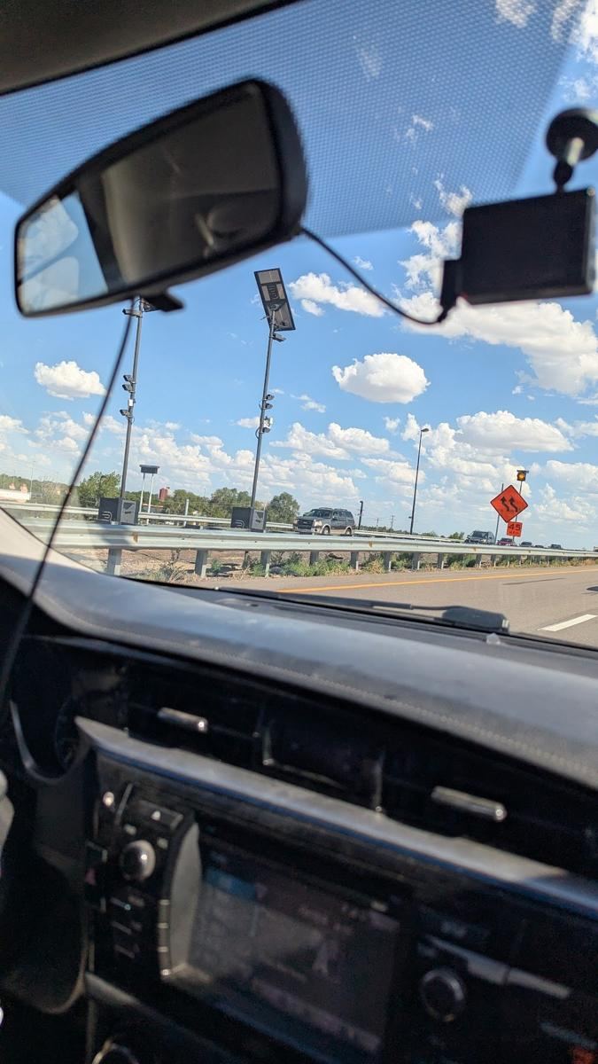Two camera towers seen through a windshield