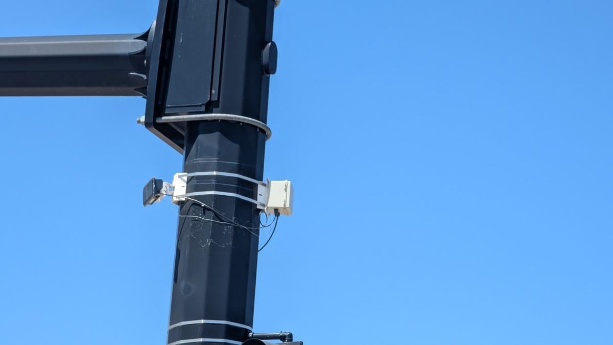 Two small sensors strapped to a signal pole