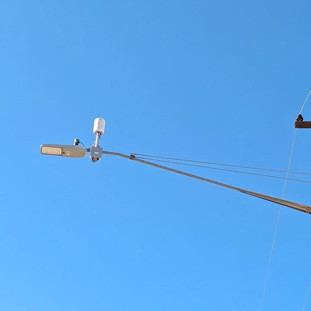 Streetlight with a white sensor on its arm