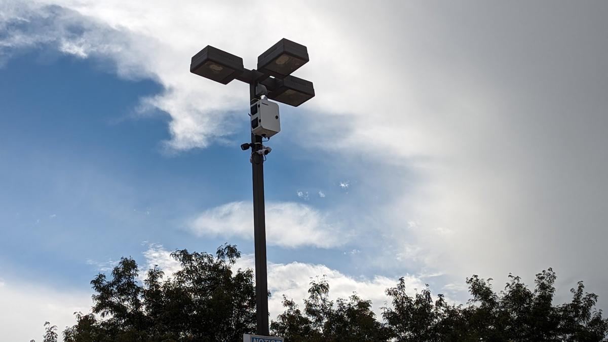 Light pole with a camera pod against clouds