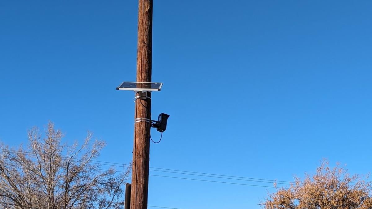 Flat solar panel above a black camera