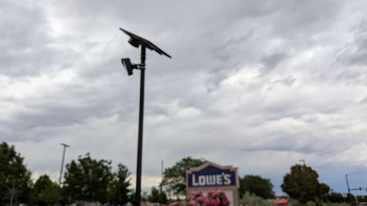 Solar camera pole near a store sign